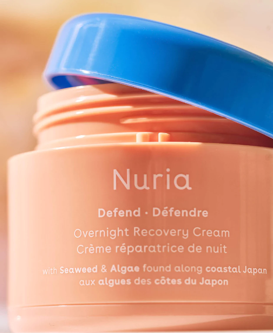 Jar of Nuria Defend Overnight Recovery Cream with lid askance. Sold at Juniper Skincare in Edina, Minnesota.